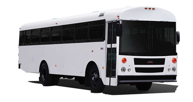 White school bus with blacked-out windows.