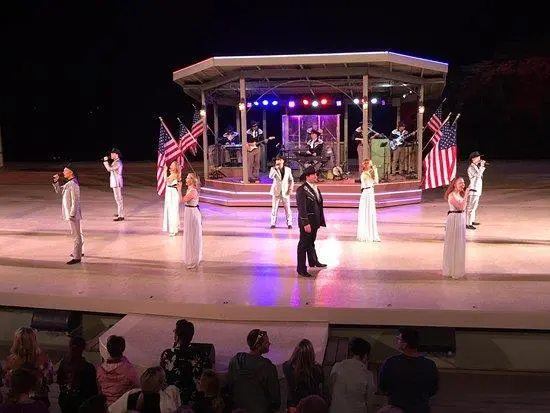 Singers perform on stage with US flags.